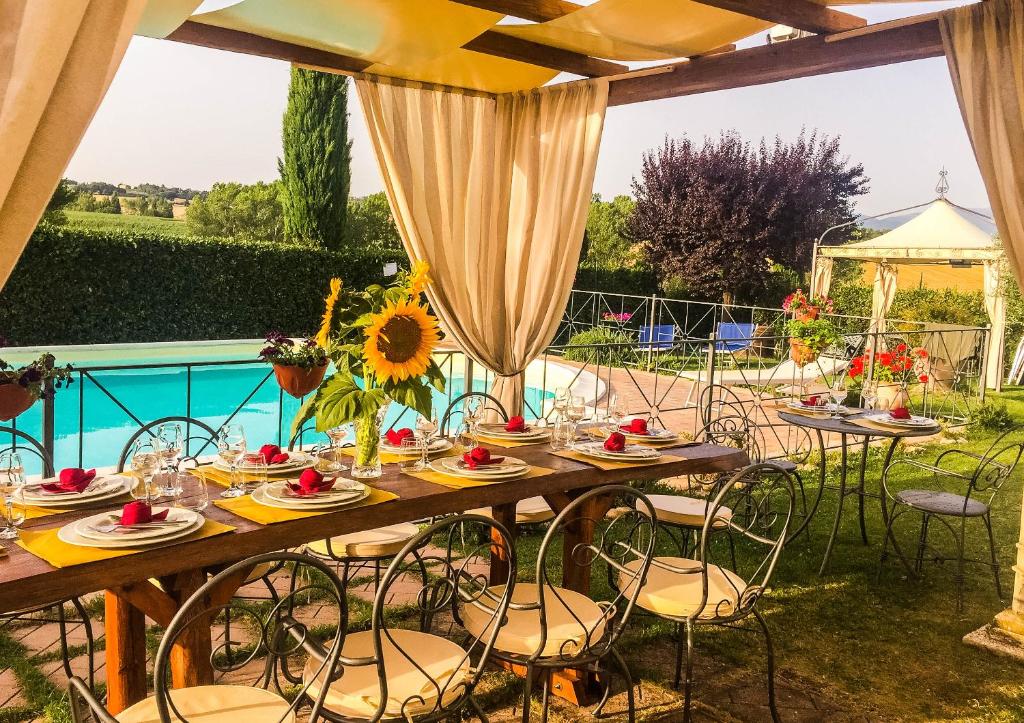 蒙特法尔科Il Poggio del Sole的桌椅、桌子和游泳池