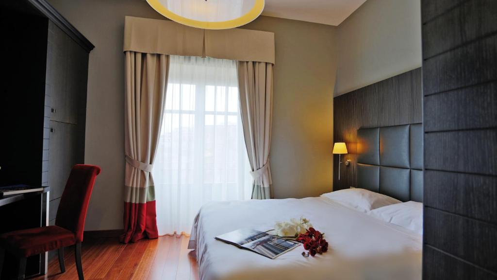 巴勒莫博塔菲里斯酒店及水疗中心的酒店客房设有床和鲜花窗户。