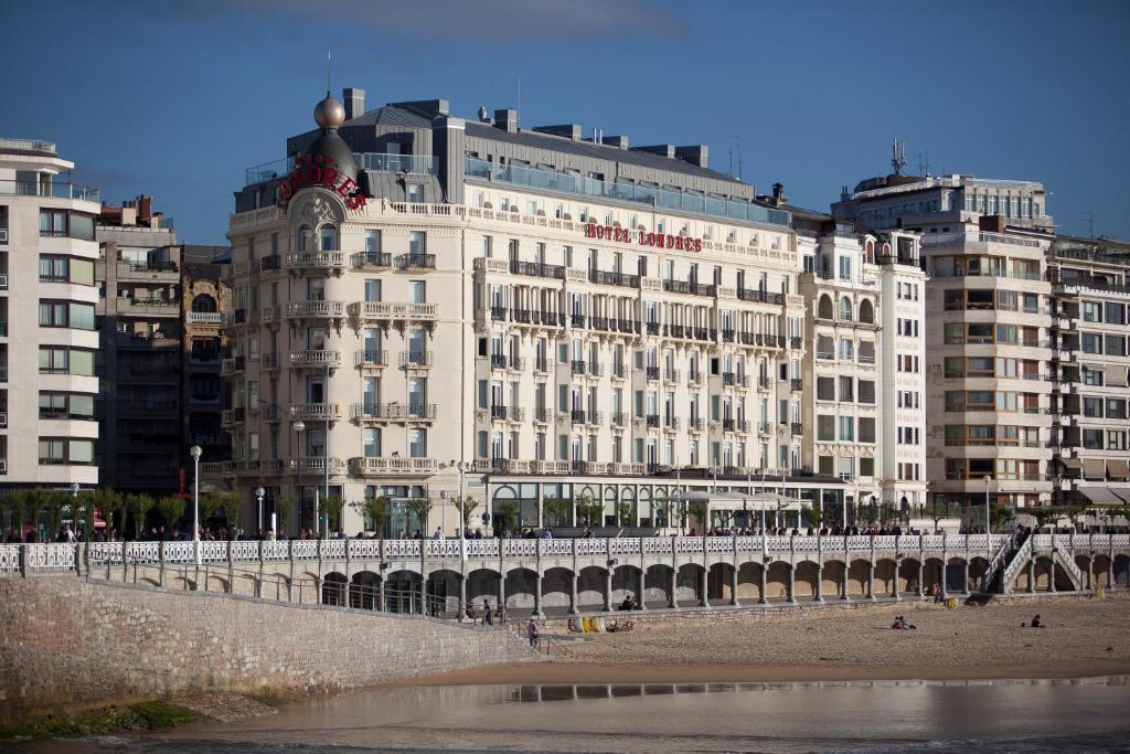 圣塞瓦斯蒂安伦德雷斯茵格拉特拉酒店的海滩上一座白色的大建筑,有建筑
