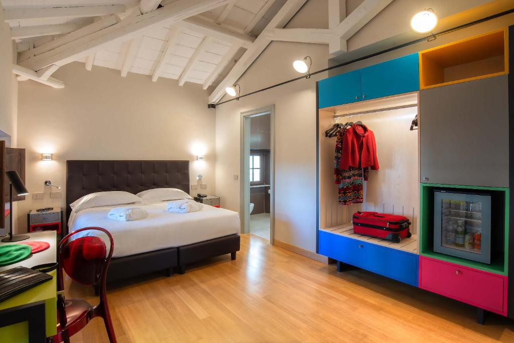 罗马Albergo Etico Roma的一间卧室配有一张床和一张带红色手提箱的书桌