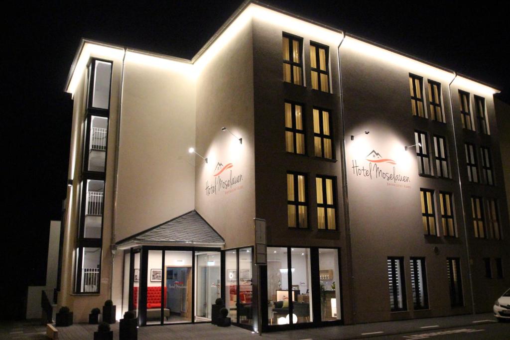 贝尔恩卡斯特尔-库斯Hotel Moselauen的一座在晚上有灯的大建筑