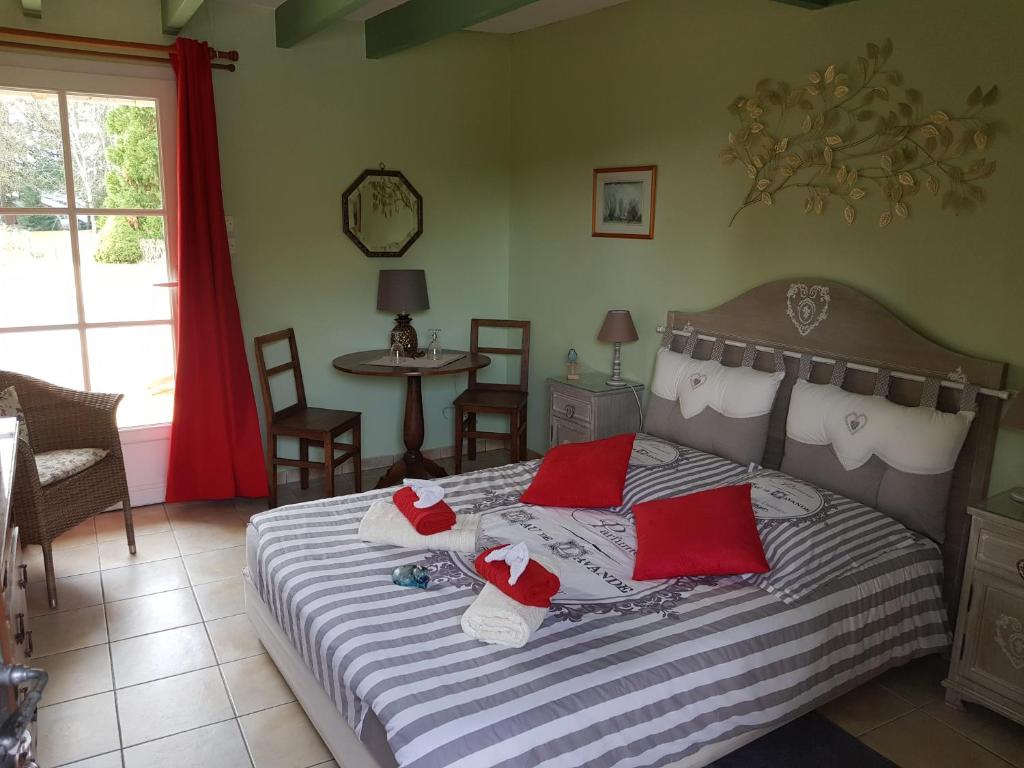 维朗德里Le Chat Courant的一间卧室配有红色和白色枕头的床