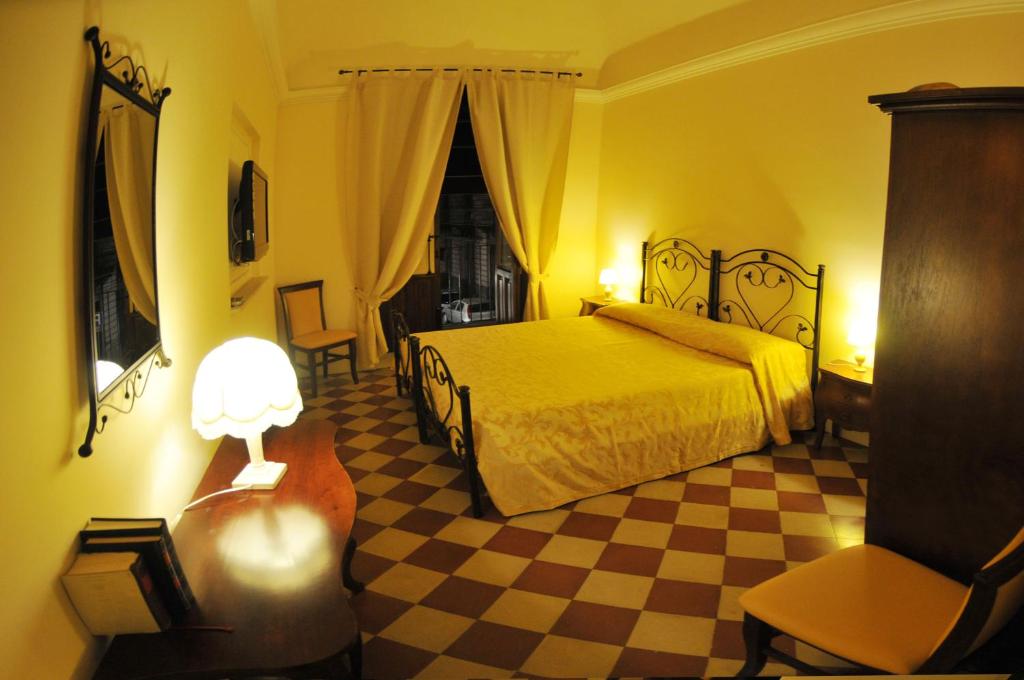 卡塔尼亚阿杜欧姆酒店的一间卧室配有一张床,铺有一个 ⁇ 板地板