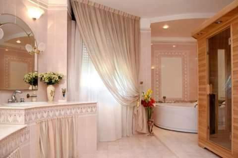San DonaciB&B Caravaggio的白色的浴室设有浴缸和大镜子