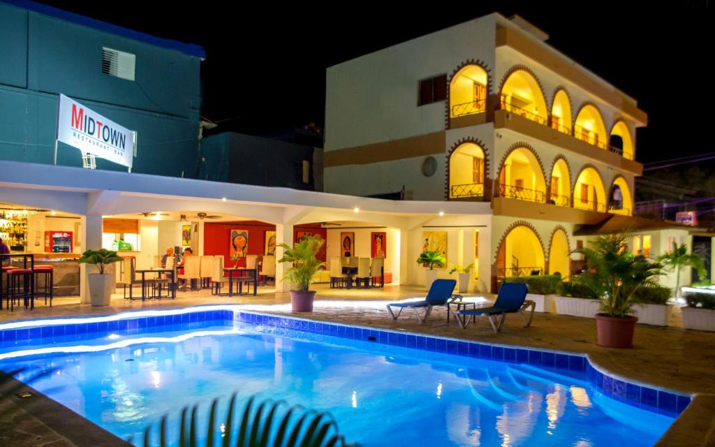 苏莎亚Hotel Las Palmeras的晚上在酒店前面的一个游泳池