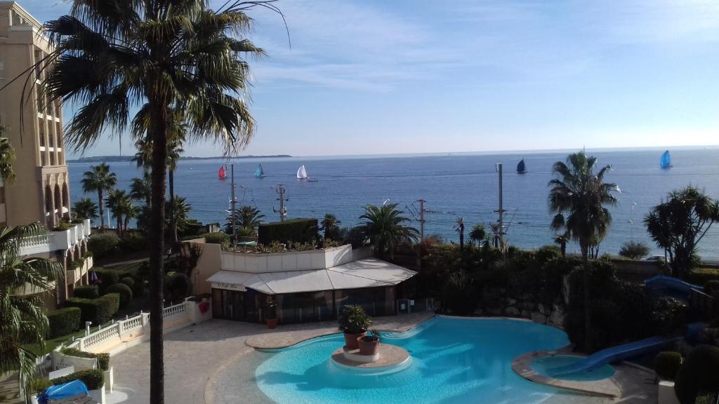 戛纳Appartement Palm d'Azur的享有游泳池和大海的景色