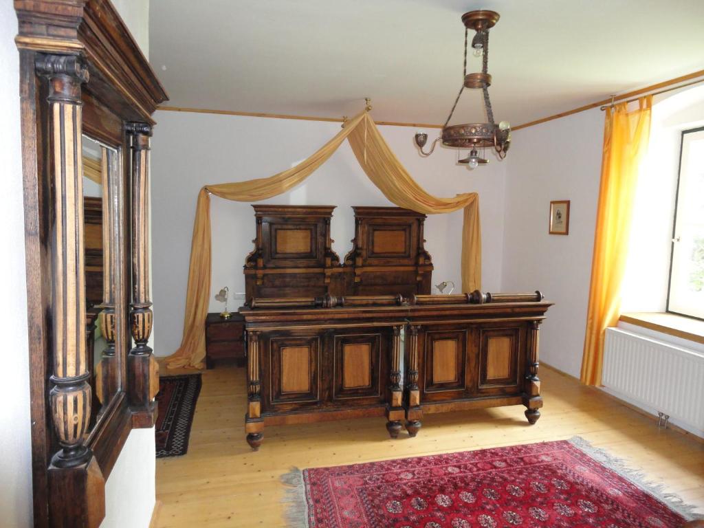 穆劳林登霍夫酒店的一间卧室配有一张木床和天篷