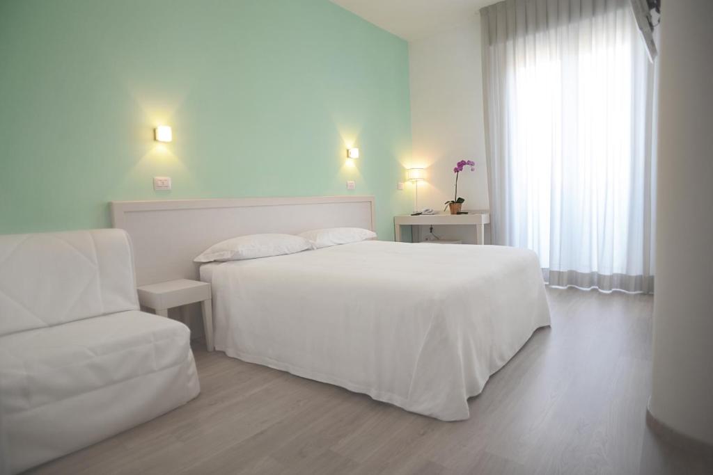 切塞纳蒂科马雷意酒店的白色的卧室配有白色的床和沙发