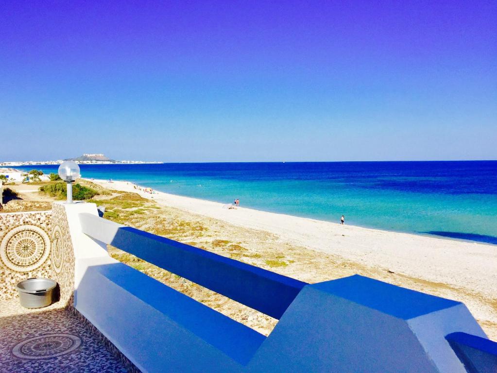 古莱比耶Casa del Mar Residence的海边的蓝色长椅