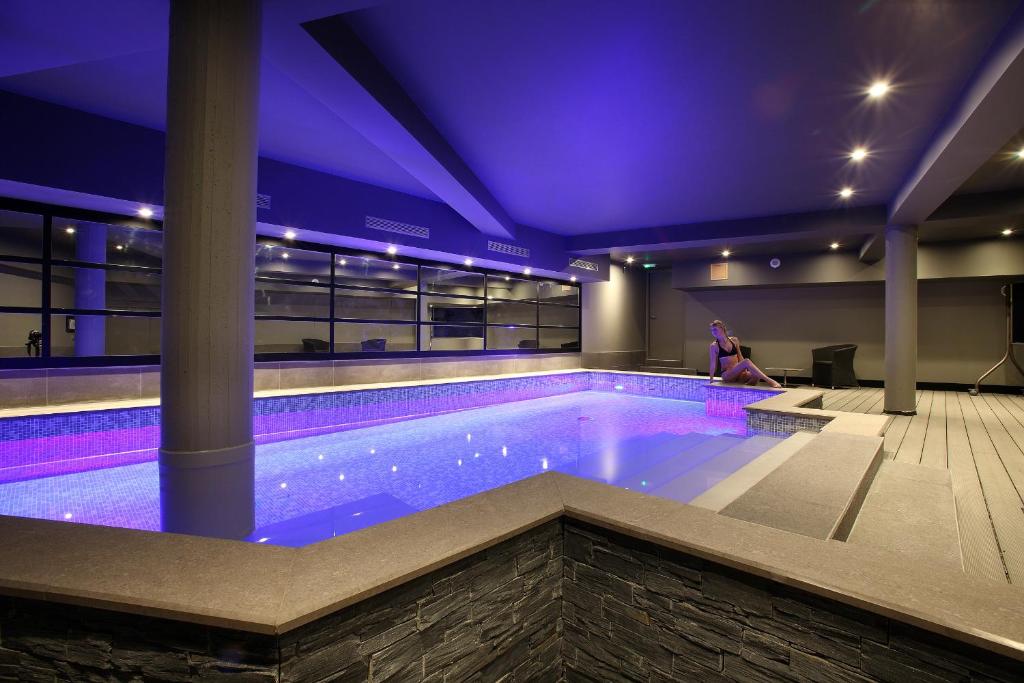 尚贝里新科海博中心酒店的一座建筑物内一座带紫色照明的游泳池