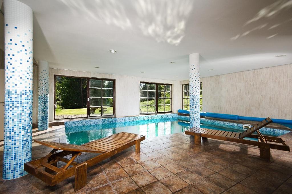 Annín安宁酒店的一个带两个长椅的游泳池