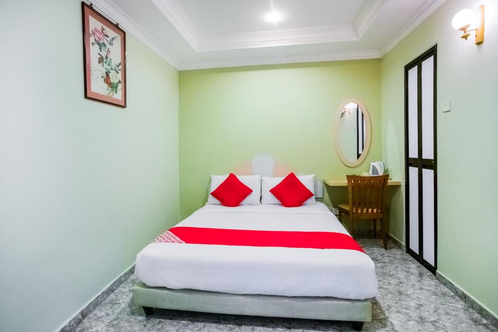 新加坡Hotel Fuji的一间卧室配有红色枕头的床