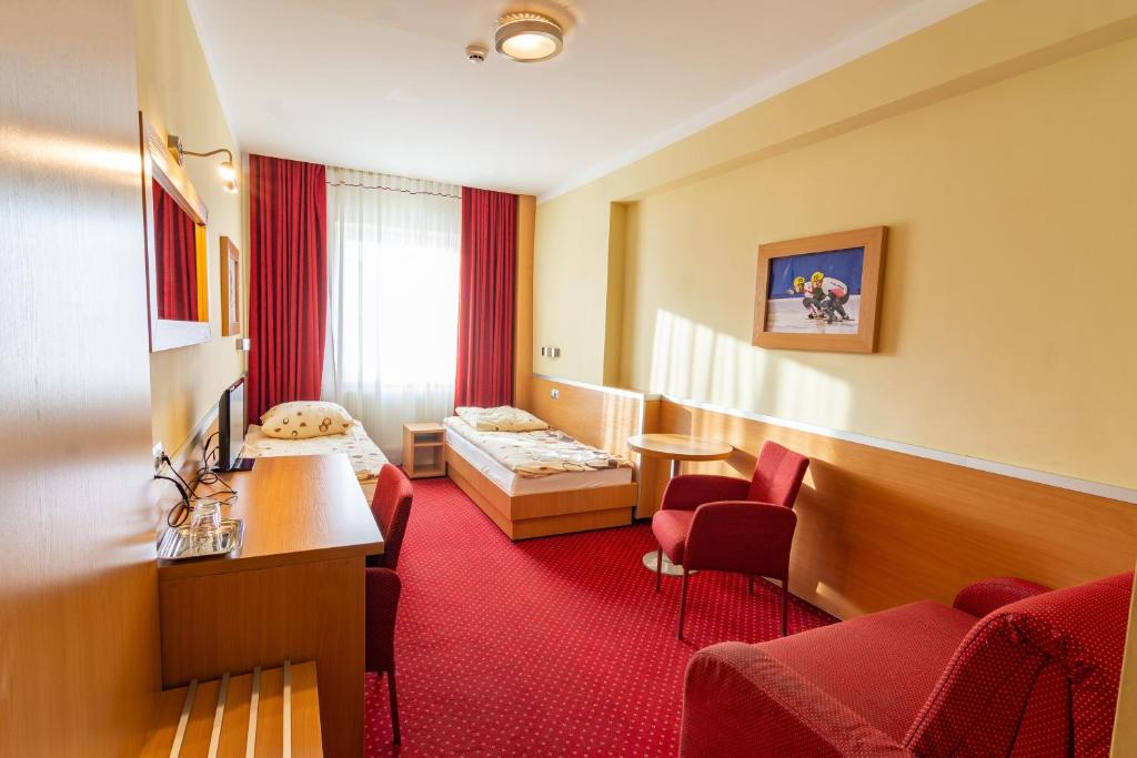 萨诺克Dom Sportowca Błonie - MOSiR的酒店客房,设有两张床,铺有红地毯。