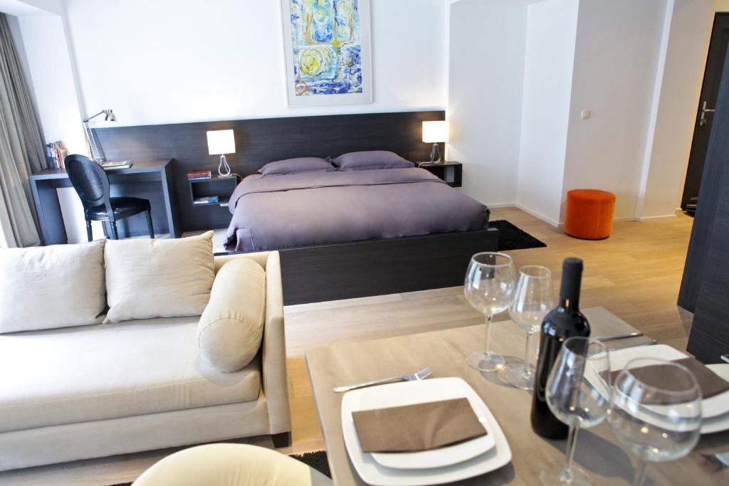 布鲁塞尔Flat Moliere的一间卧室配有一张床、一张沙发和一张桌子