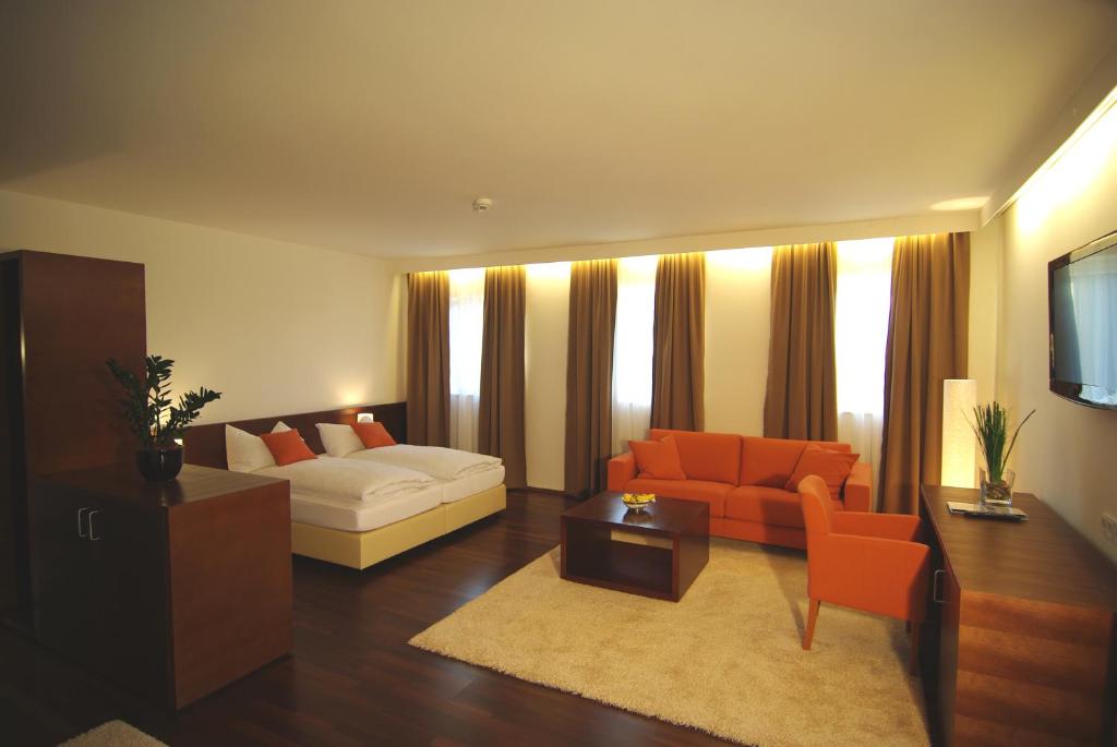 施泰尔克里斯特金德维尔特餐厅酒店的客厅配有白色沙发和橙色椅子