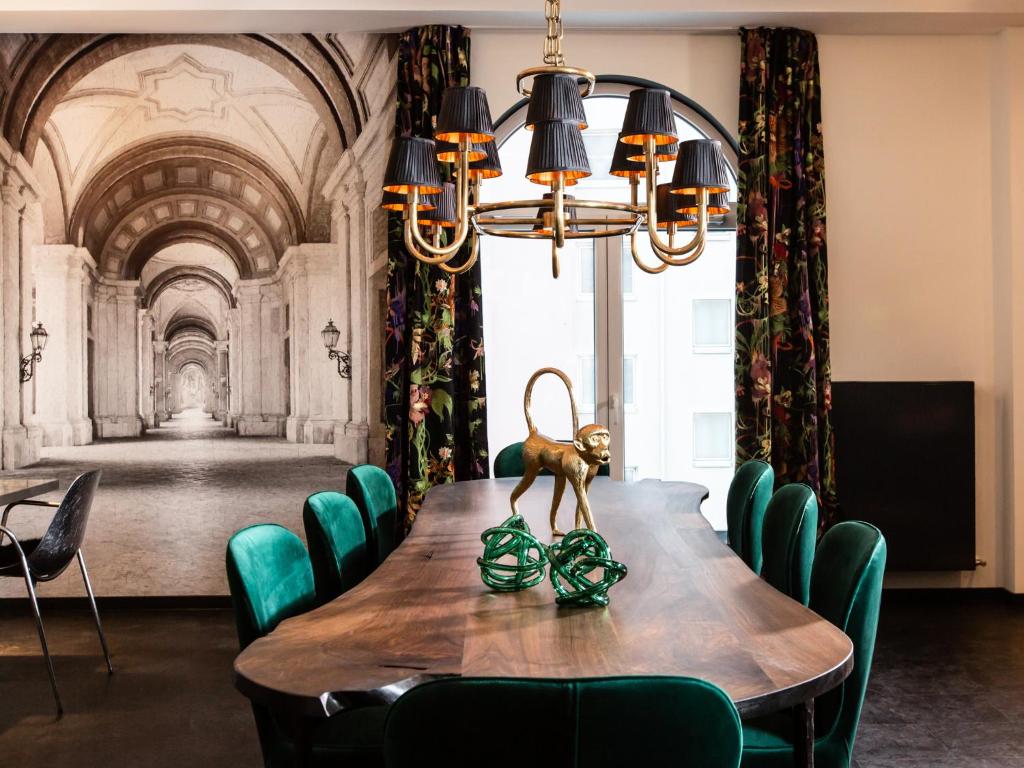 巴特瑙海姆Boutique Hotel K7的用餐室配有带绿椅的桌子