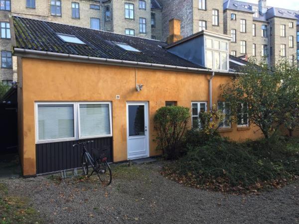 哥本哈根Rooms in quiet Yellow Courtyard Apartment的一辆自行车停在房子前面