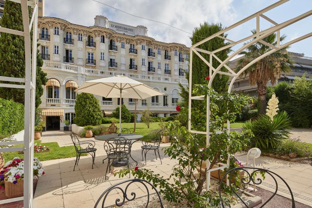 圣拉斐尔Residence Vacances Bleues le Mediterranée的一个带桌椅的庭院和一座建筑