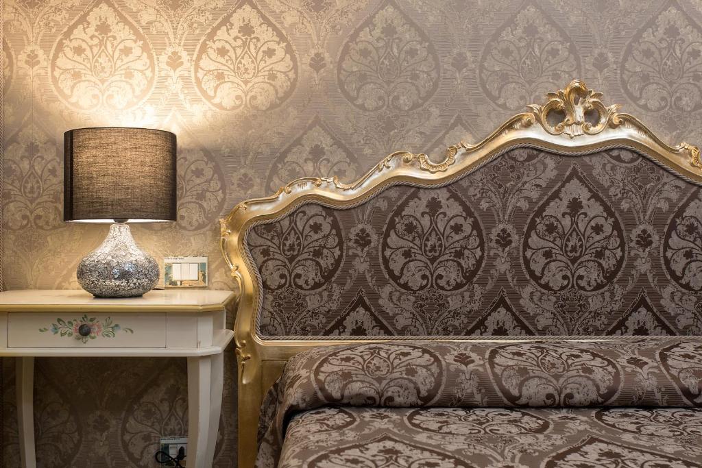 威尼斯梅佐波卓酒店的一间卧室配有一张床和一张带台灯的桌子