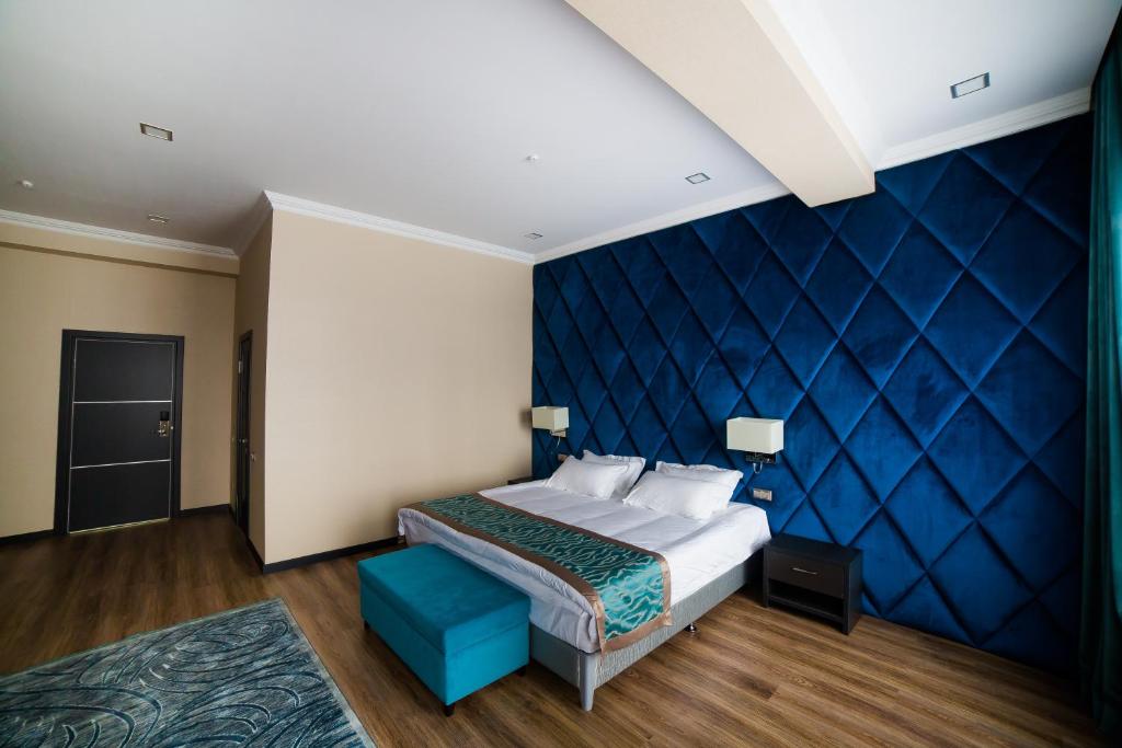 比什凯克Golden Hotel的一间卧室设有一张床和蓝色的墙壁