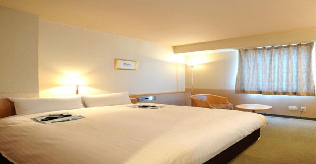 米泽市Hotel Benex Yonezawa / Vacation STAY 14346的一间设有大床和窗户的酒店客房