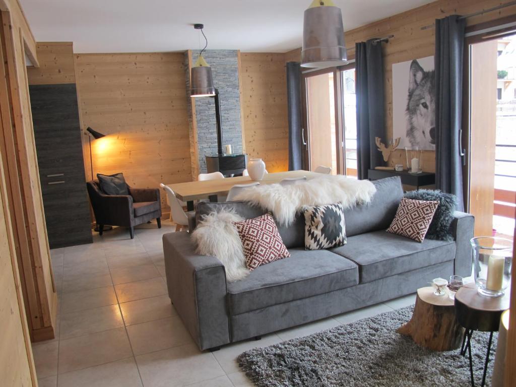 瓦卢瓦尔Le Bianca 102 Residence l'Epinette的客厅配有带枕头的灰色沙发