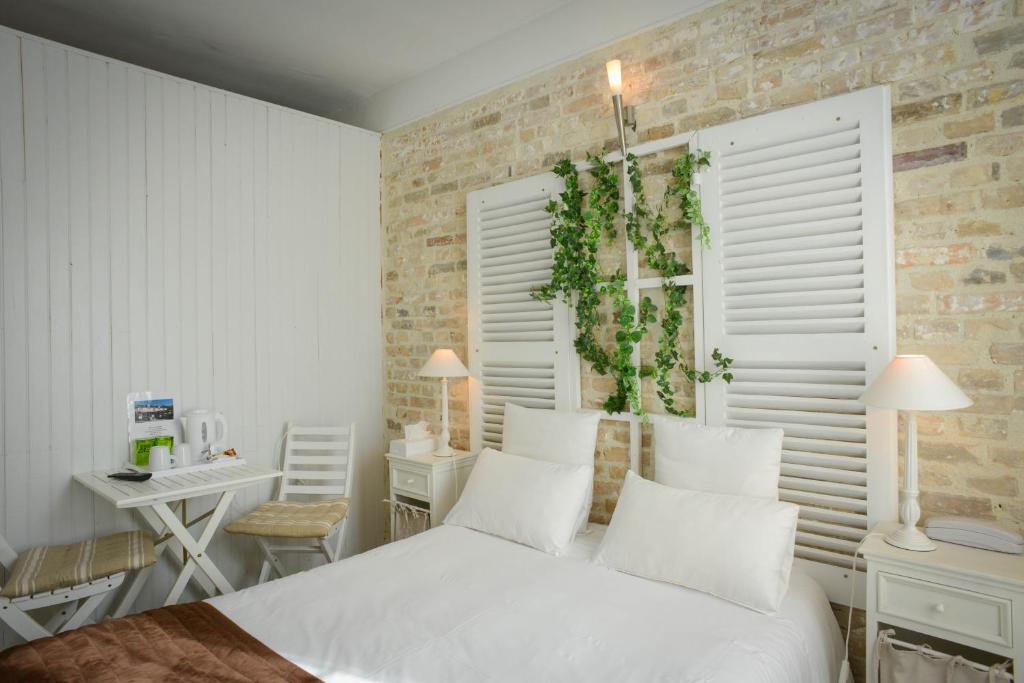 卡朗唐奥贝奇诺曼德酒店的卧室配有白色的床、桌子和书桌