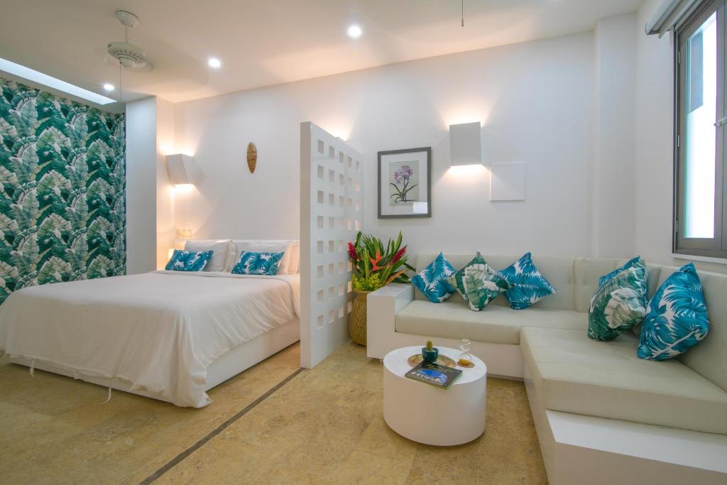 圣玛尔塔El Cactus Luxury Apartments in Historic Center的一间卧室配有一张床和一张沙发