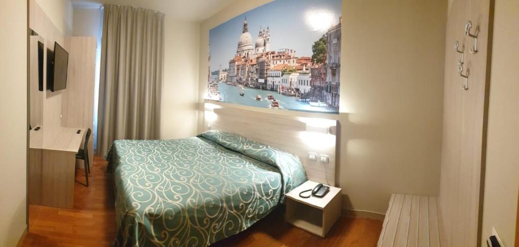法瓦罗威尼托阿尔蒂里酒店的酒店客房设有一张床,墙上挂着一张照片