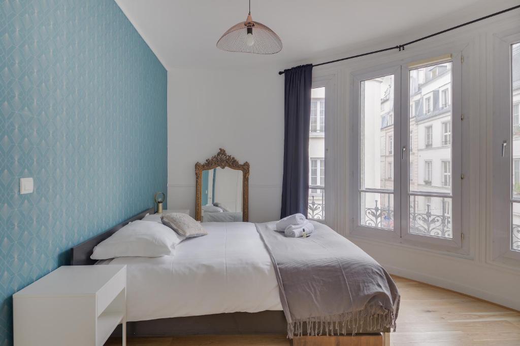 巴黎Lovely Parisian Flat - Louvre rue St Honoré的一间卧室配有一张蓝色墙壁的床