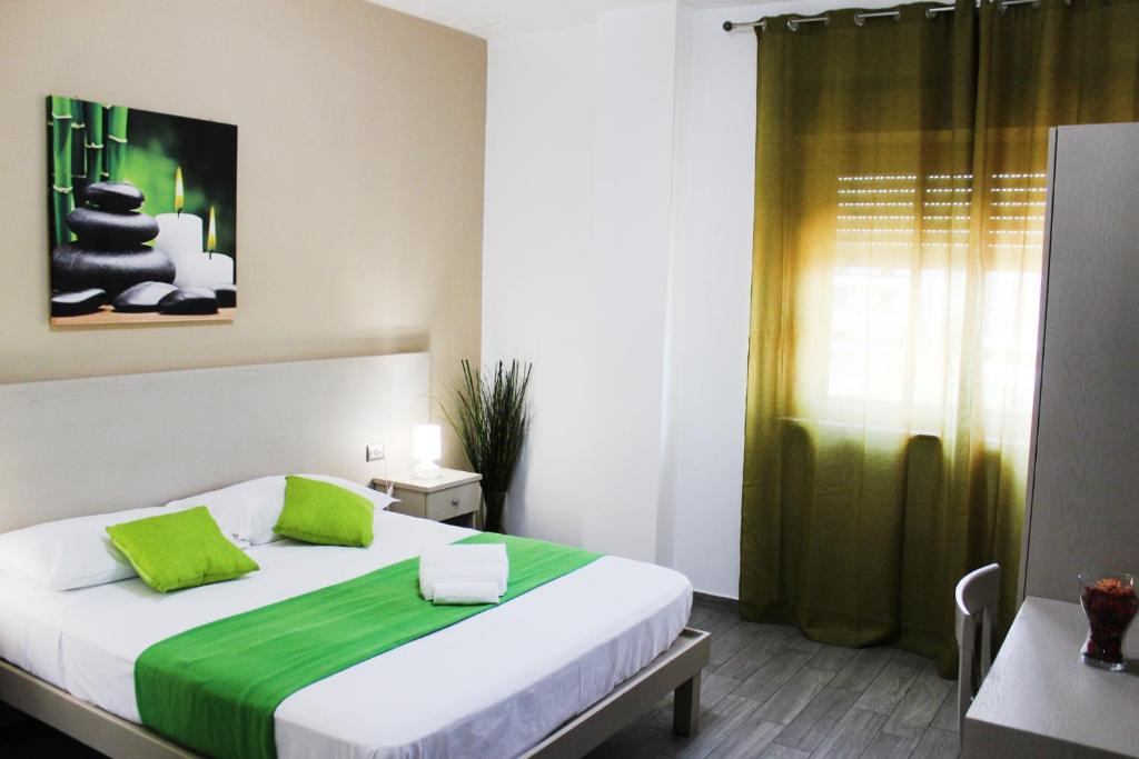 CasavatoreHotel Cesirja的一间卧室配有一张带绿色枕头的大床