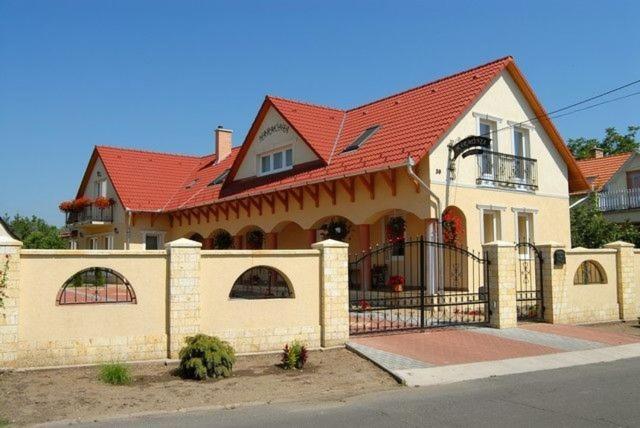 沙罗什保陶克Harmónia Panzió的一座红色屋顶的大房子