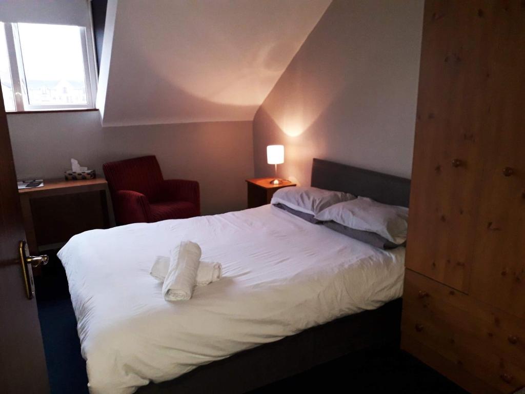 贝尔法斯特拉威尔奥缪旅馆的一间酒店客房,配有一张带毛巾的床