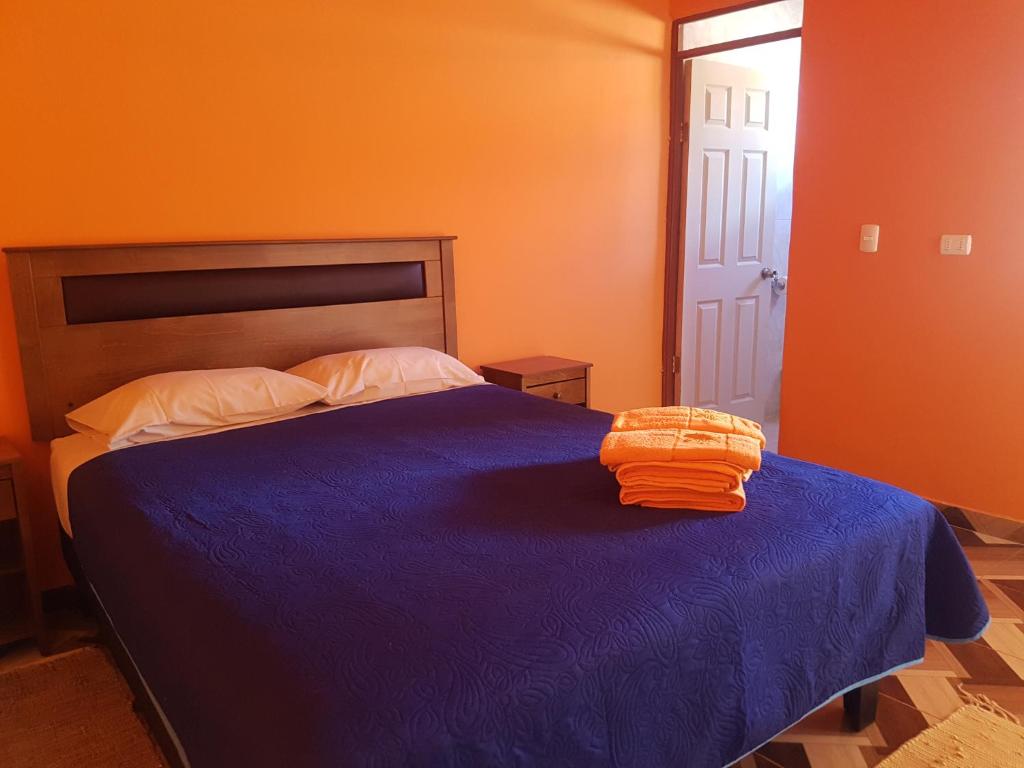 圣佩德罗·德·阿塔卡马Hostal Casa Colque的一间卧室配有一张蓝色的床和橙色的墙壁