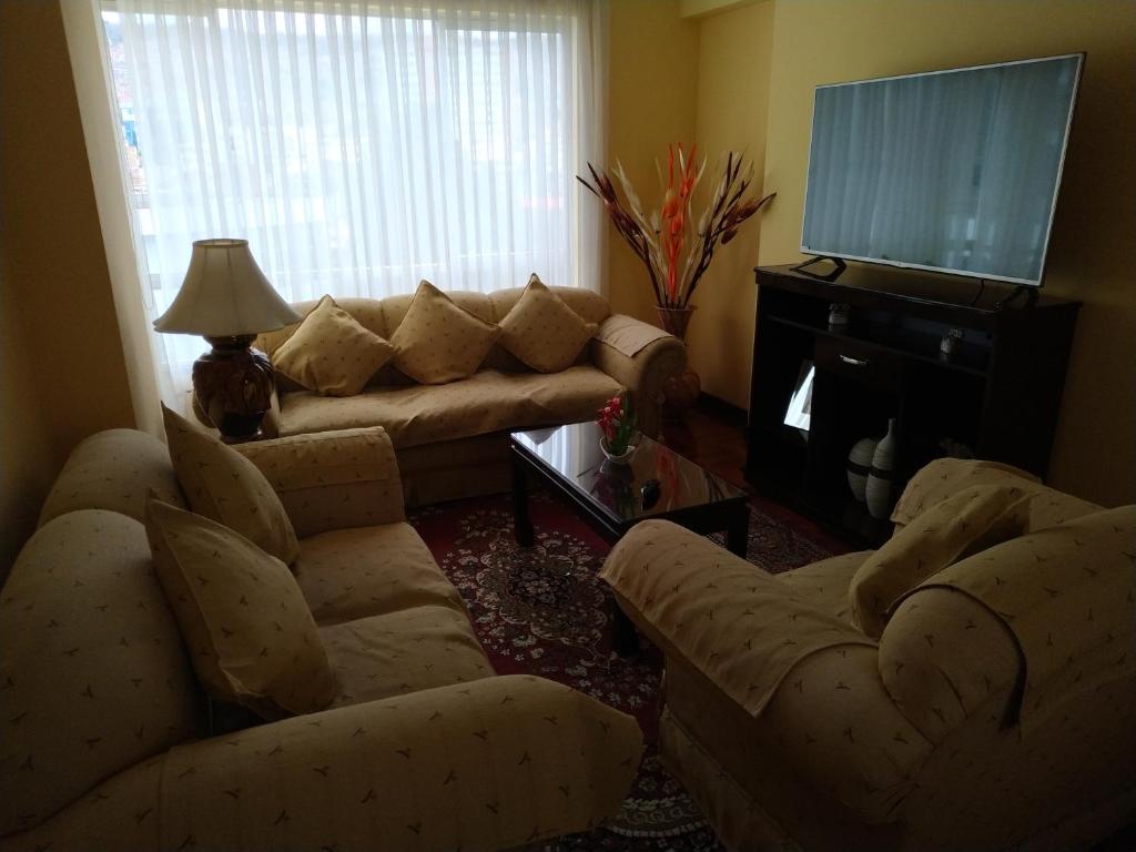 拉巴斯Apartamento Exclusivo VIP的客厅配有沙发、椅子和电视