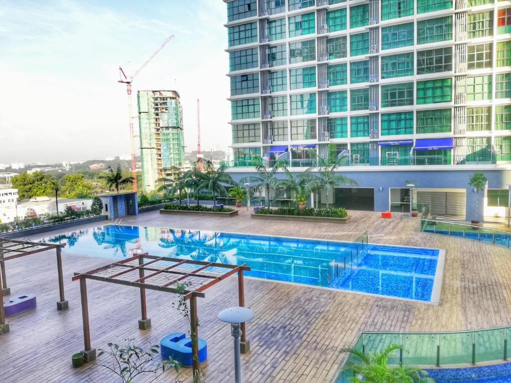 莎阿南Guesthouse at Shah Alam的一座高楼前的游泳池