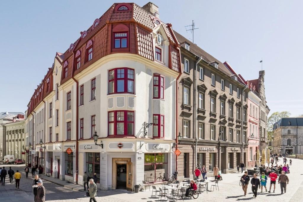 塔林Great apartament in a heart of Tallinn的城市街道上一座带红色窗户的大型建筑