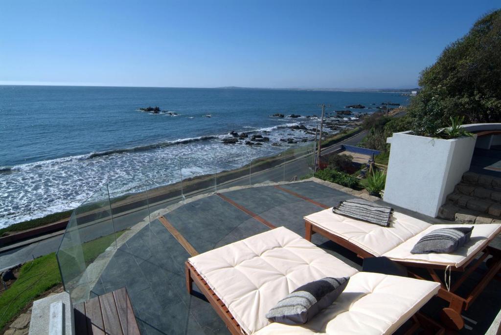 康康卡萨多卡精品酒店的阳台配有2把躺椅和海洋
