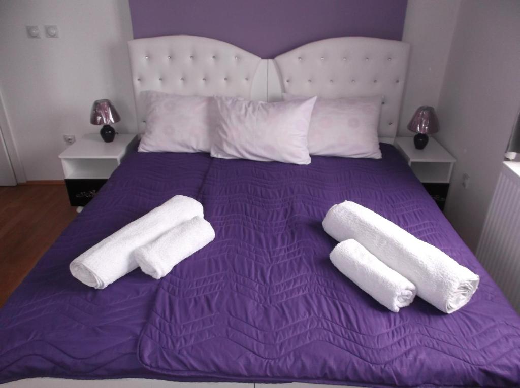 弗拉涅Prenociste Bojan 017的紫色的床,上面有两条白色毛巾