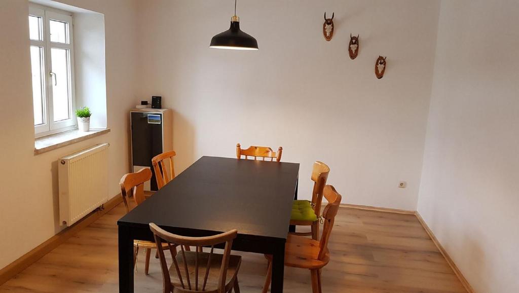 ErbendorfFerienwohnung Trogschneider Hof的一间用餐室,配有黑色的桌子和椅子