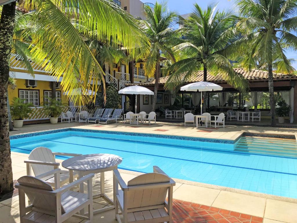 卡波布里奥Hotel Mar de Cabo Frio的酒店旁的游泳池配有椅子和遮阳伞