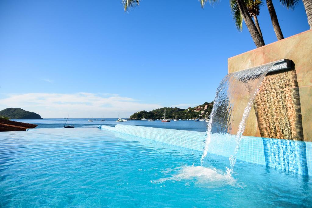 锡瓦塔塔内霍Arena Suites的一座带喷泉的游泳池,位于大海前