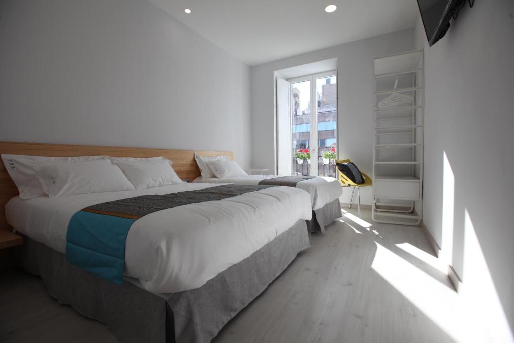 马德里Hostal Palacio Luna的一间卧室设有两张床和窗户。