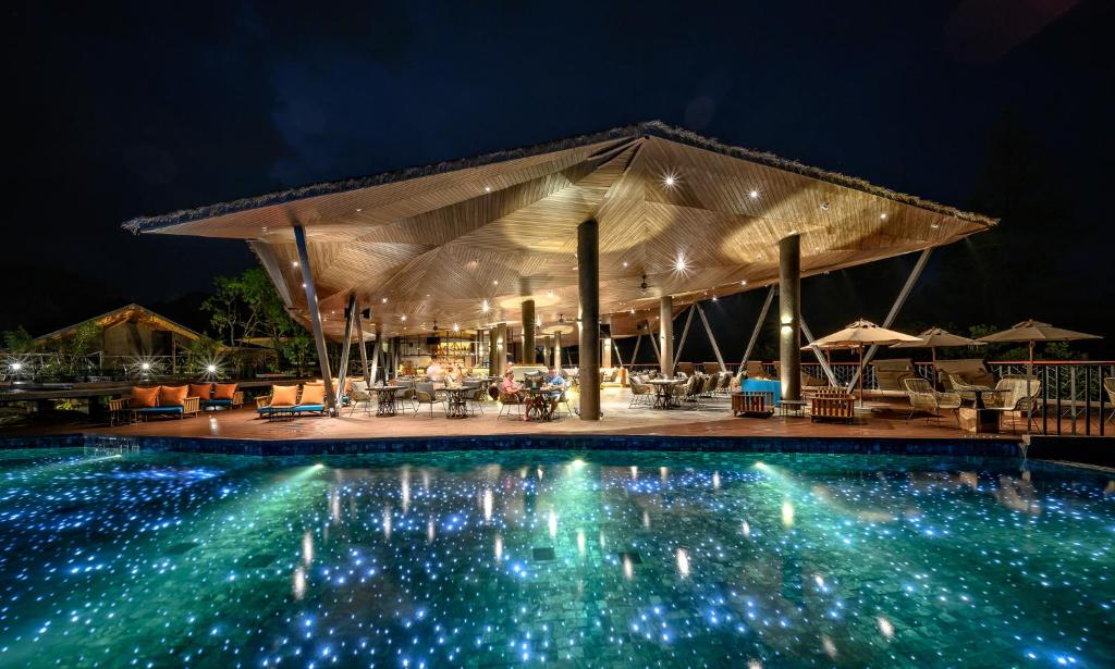 蔻立Kalima Resort and Villas Khao Lak - SHA EXTRA PLUS的游泳池,晚上设有凉亭