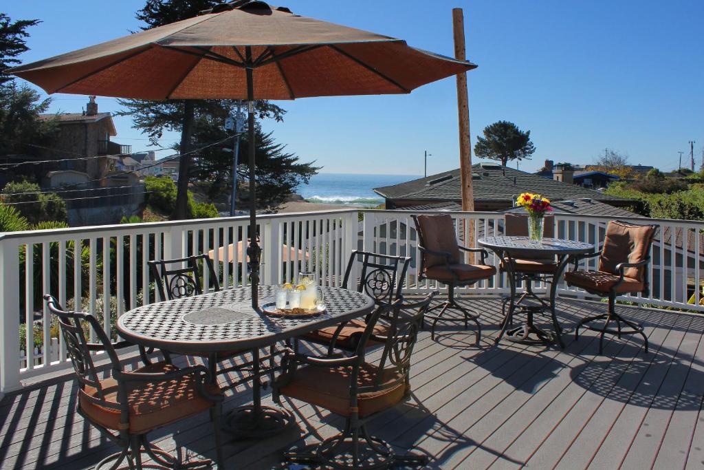 圣克鲁兹海洋回波海滩别墅酒店 的一个带桌椅和遮阳伞的庭院