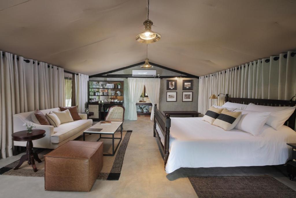 维勒珀图Leopard Trails Wilpattu的一间卧室设有一张床和一间客厅。