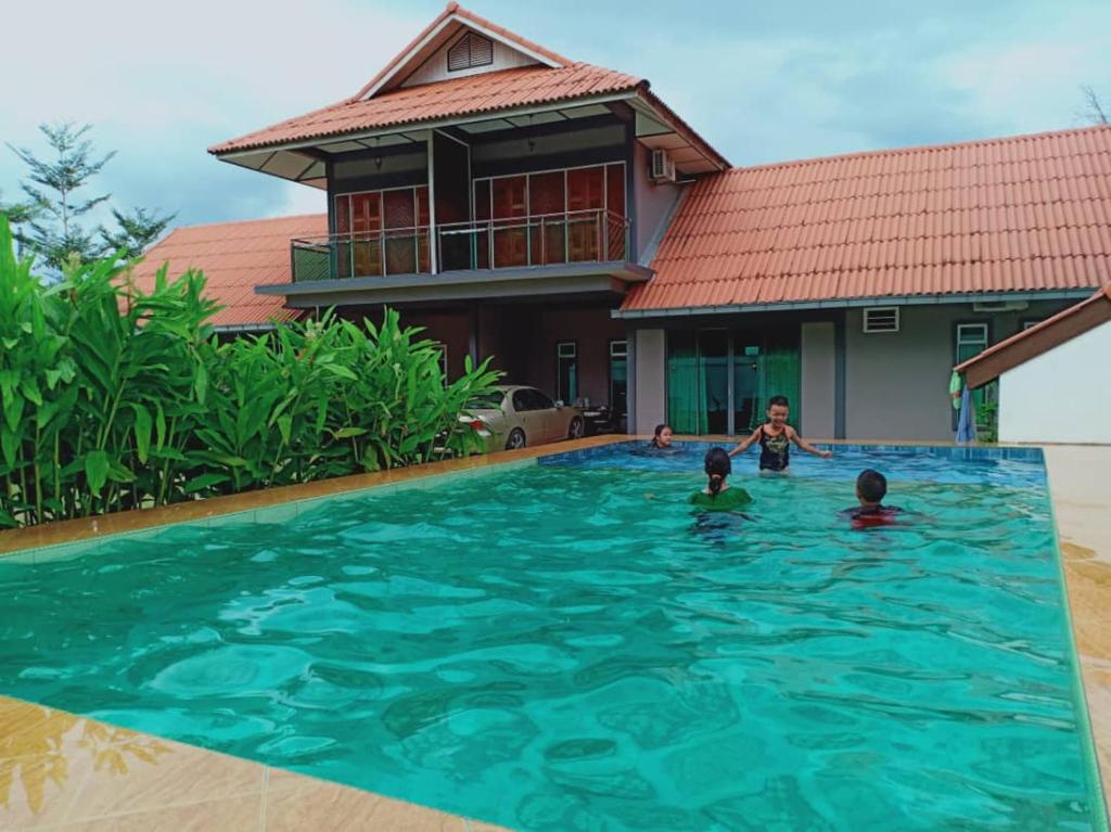 瓜埠斯里特蚌告度假屋的一群孩子在房子的游泳池里