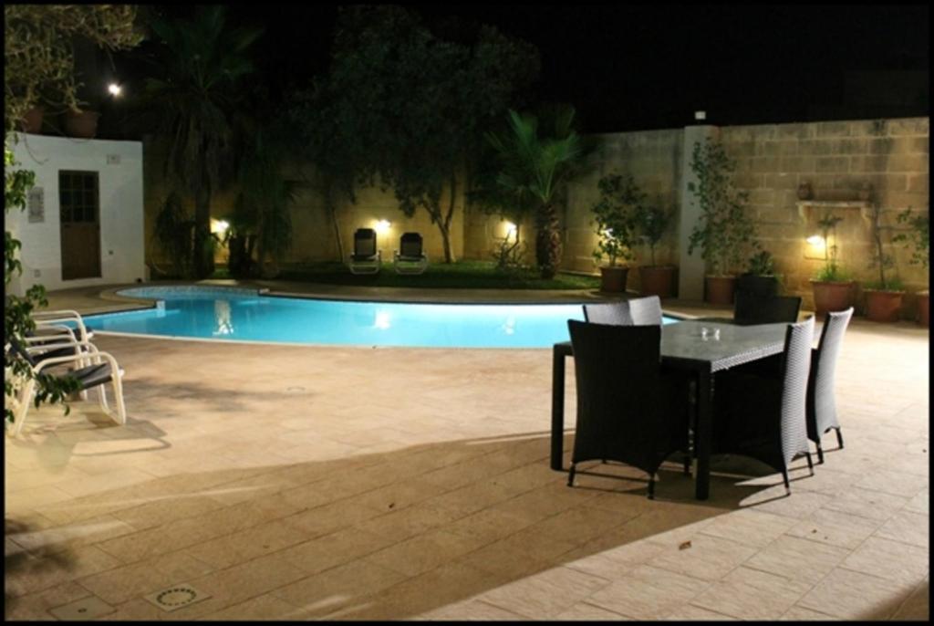 纳克萨Malta Villa的游泳池前的一张桌子和椅子