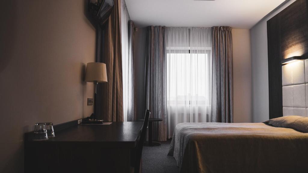 克莱佩达维兰塔纳汽车旅馆的配有一张床、一张书桌和一扇窗户的酒店客房