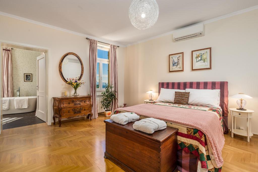 奥帕提亚Villa Vilma的一间卧室配有一张床,浴室设有浴缸